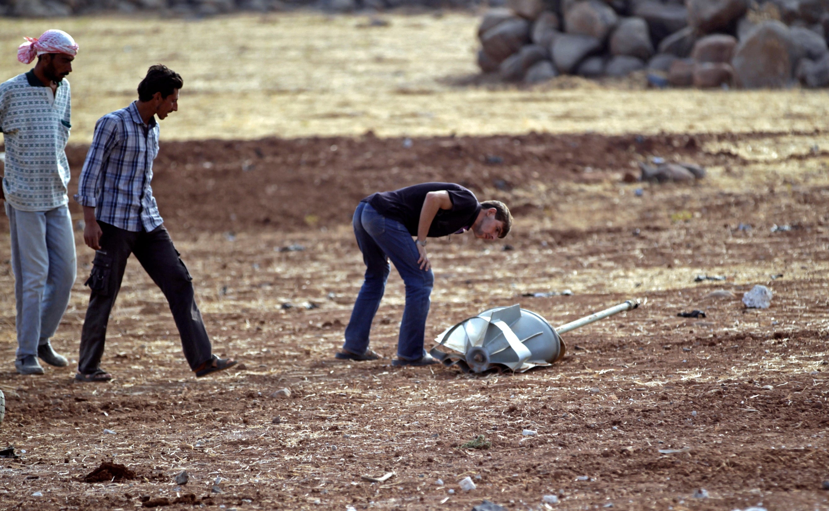 Homens inspeccionam os restos de um projetil russo, em Idlib, S&iacute;ria Foto: Reuters