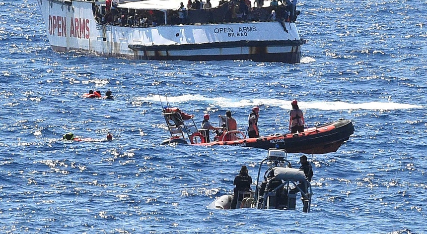 Migrantes tentando nadar do navio "Open Arms" para terra
