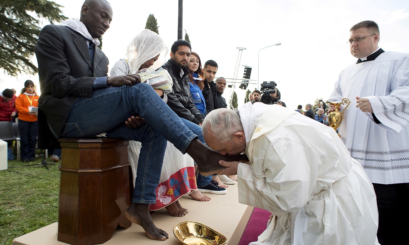  Papa Francisco beija o p&eacute; de um refugiado durante o ritual de lava-p&eacute;s no centro de refugiados de Castelnuovo di Porto, perto de Roma | Vaticano via Reuters 