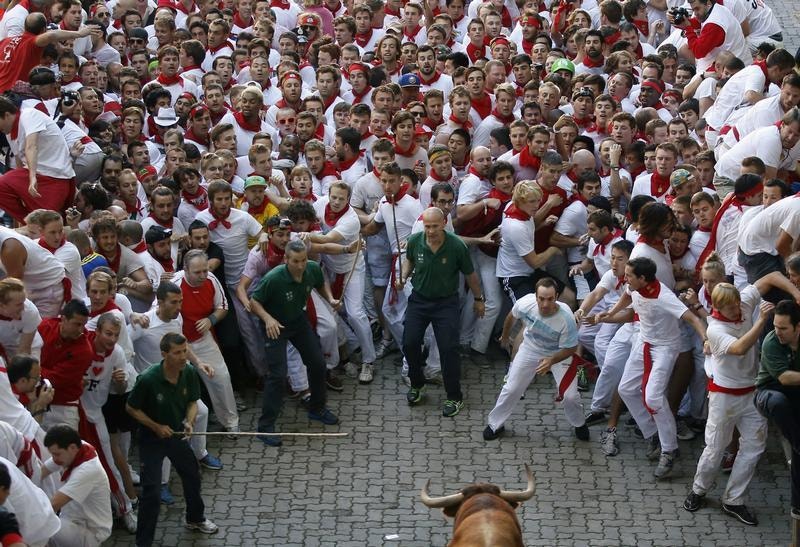  Um touro enfrenta a multid&atilde;o de corredores no primeiro dia das largadas. Susana Vera / Reuters 