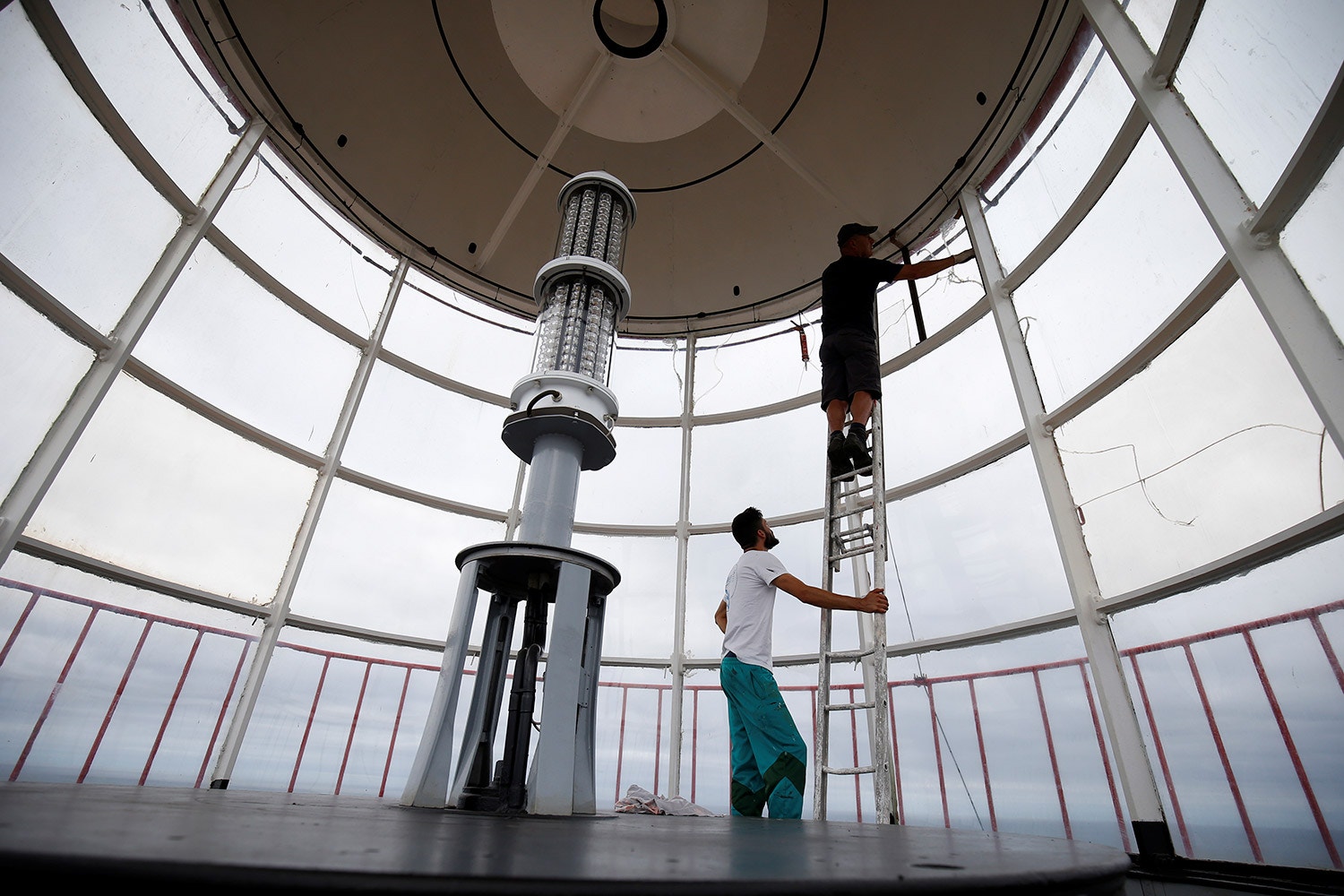  Os faroleiros Pedro Sousa e Lu&iacute;s Silva tratam da manuten&ccedil;&atilde;o dentro da sala da lanterna 