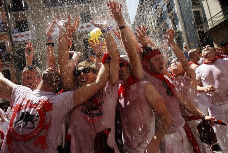  Durante o "Chupinazo", o lan&ccedil;amento de foguetes, os festeiros d&atilde;o in&iacute;cio &agrave;s comemora&ccedil;&otilde;es. Joseba Etxaburu / Reuters 