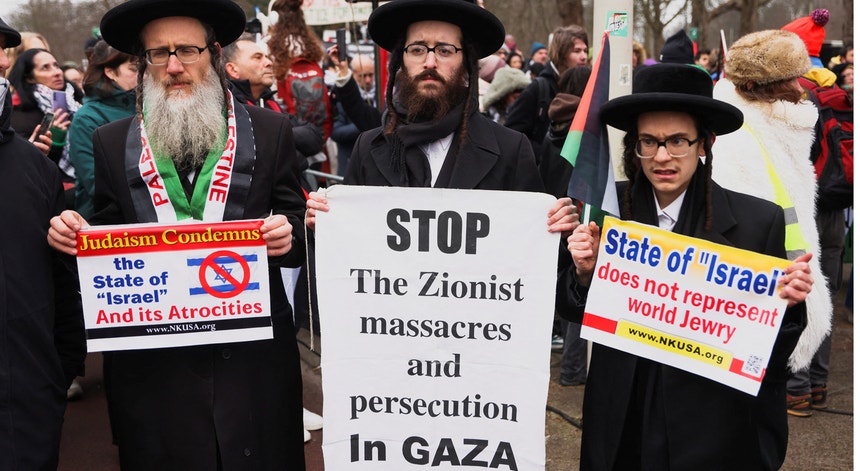 Manifestantes judeus seguram cartazes com mensagens dirigidas ao governo israelita, perto do Tribunal Internacional de Justiça em Haia, Países Baixos 
