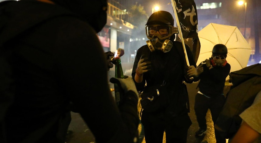 Os manifestantes usam máscaras de gás para resistirem ao gás lacrimogéneo e simultaneamente ocultarem a sua identidade
