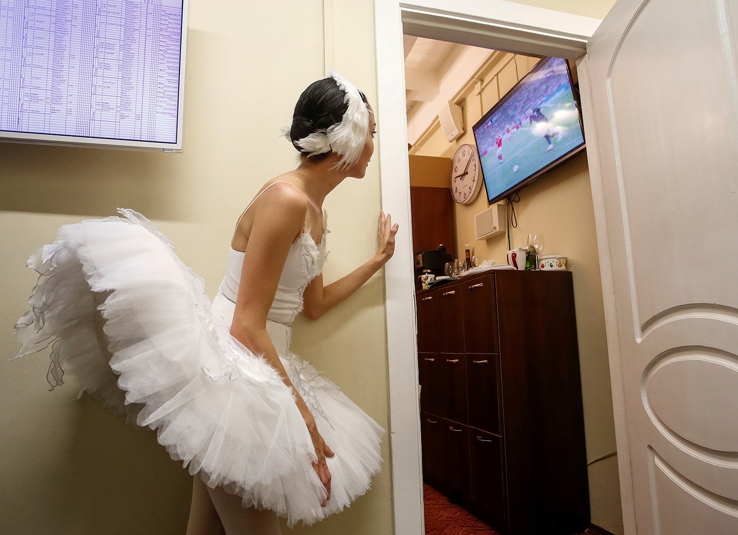  Uma bailarina aproveita para espreitar o jogo entre a R&uacute;ssia e a Cro&aacute;cia durante o Mundial de Futebol /Anton Vaganov - Reuters 
