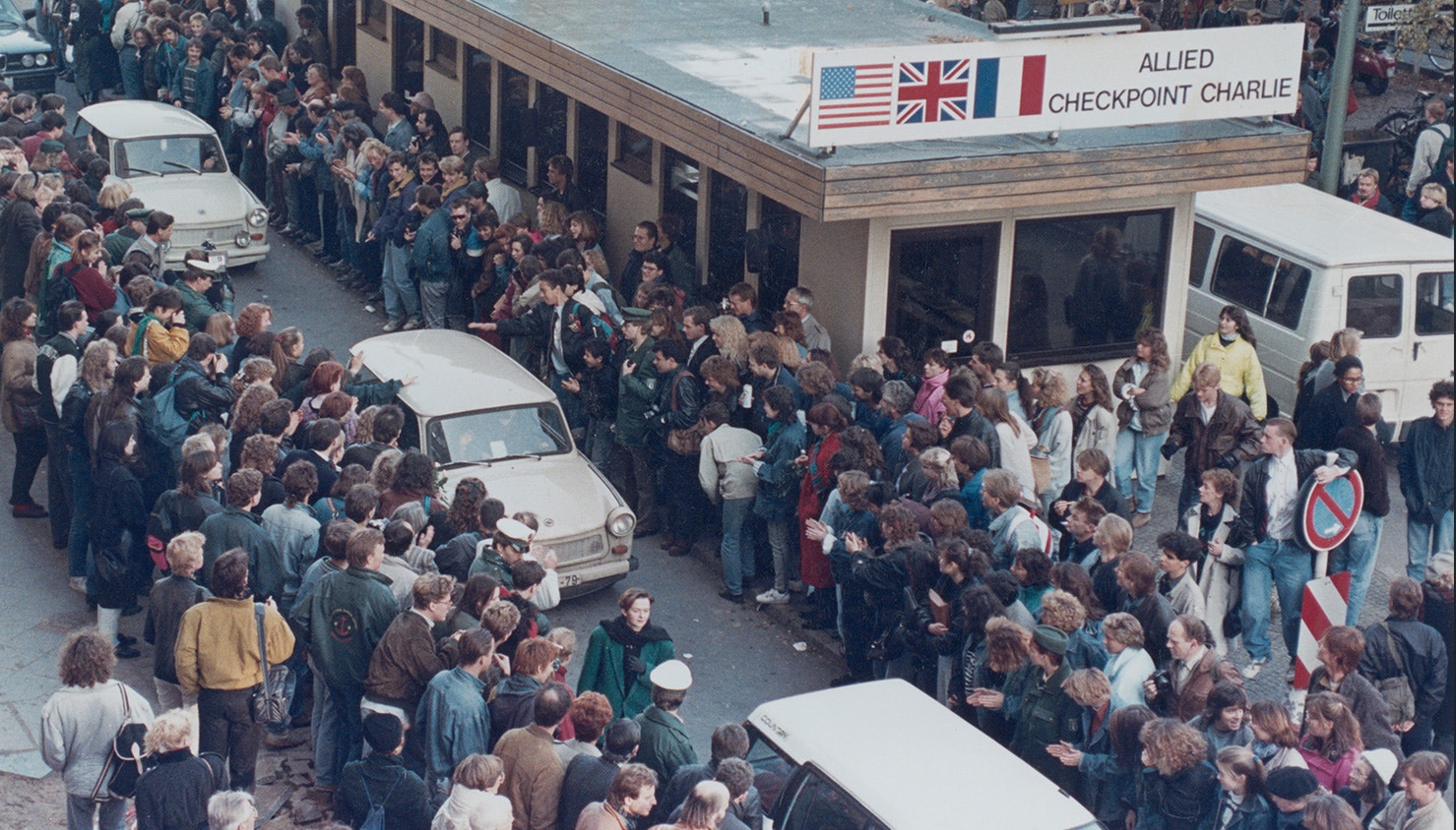  Os alem&atilde;es ocidentais aplaudem quando os cidad&atilde;os de Berlim Oriental atravessam o Check point Charlie. 10 de novembro de 1989 | David Brauchli - Reuters 