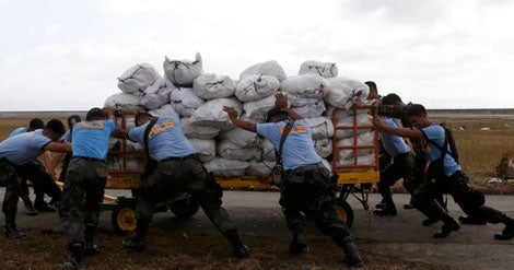 Filipinos descarregam auxilio humanit&aacute;rio &agrave;s v&iacute;timas do tuf&atilde;o Haiyan em Tacloban, Filipinas (Reuters)
