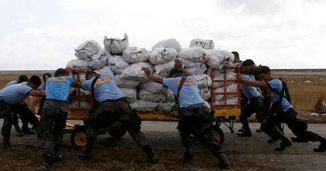 Filipinos descarregam auxilio humanitário às vítimas do tufão Haiyan em Tacloban, Filipinas (Reuters) Filipinos descarregam auxilio humanitário às vítimas do tufão Haiyan em Tacloban, Filipinas (Reuters)