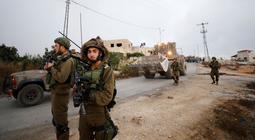Soldados israelitas ocupam posições durante a demolição da casa de um alegado atacante palestiniano em Khobar, na Cisjordânia, uma operação realizada em agosto deste ano
