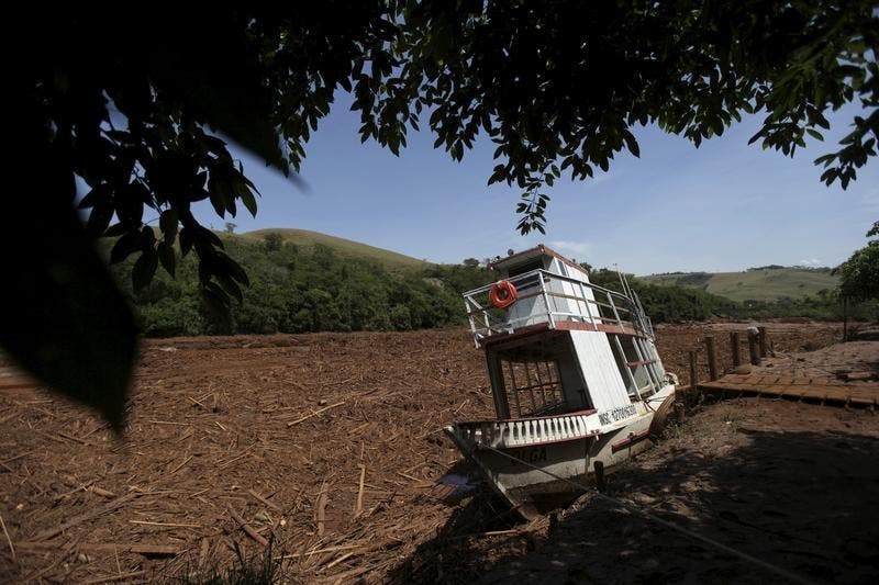 Um barco encalhado na margem do Rio Doce após o rebentamento de uma barragem de lamas de minério em Bento Rodrigues. Todas as atividades económicas em torno do Rio Doce estão paralisadas há vários dias Foto: Reuters Um barco encalhado na margem do Rio Doce após o rebentamento de uma barragem de lamas de minério em Bento Rodrigues. Todas as atividades económicas em torno do Rio Doce estão paralisadas há vários dias Foto: Reuters