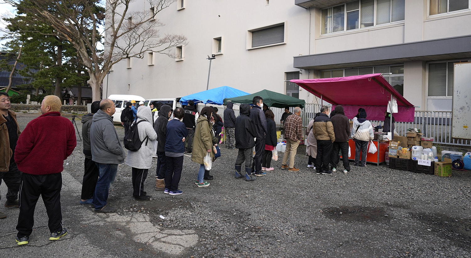  Moradores aguardam em fila para receber alimentos em Wajima, a 4 de janeiro de 2024. Cerca de 33 mil residentes na regi&atilde;o procuraram ref&uacute;gio em 355 centros de evacua&ccedil;&atilde;o improvisados. De acordo com a Hokuriku Electric Power Company, cerca de 33.900 resid&ecirc;ncias ficaram sem eletricidade. | Foto: Franck Robichon &ndash; EPA 